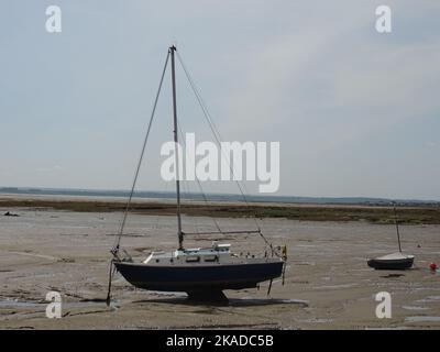 A single yacht in low-tide estuary mud in Leigh-on-Sea, Essex, England Stock Photo