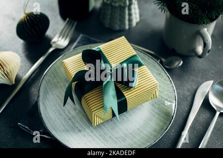 Christmas or New Year Table Setting. Craft blue plate with cutlery on gray stone background. Close-up. Stock Photo