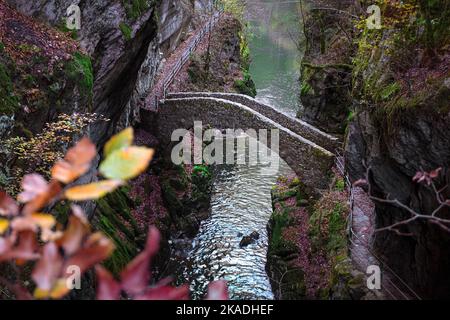 Gorges de l'Areuse, Noiraigue , Neuchatel, Switzerland, Europe. Romantic stone bridge over the river with autumn Jura mountains landscape. Stock Photo