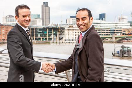 London Business Agreement. A warm and friendly greeting between diverse businessmen by the River Thames. From a series of related images. Stock Photo