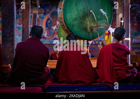 Young monks with a drum at Thikse Monastery (Gompa) during morning puja, Ladakh, India Stock Photo