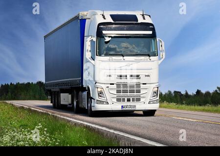 White Volvo FH truck pulls semi trailer on highway E63 on a beautiful day of summer. Jämsä, Finland. June 6, 2019. Stock Photo