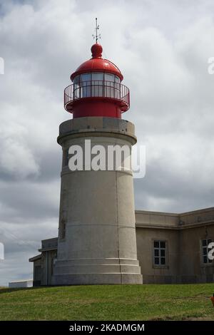 A vertical shot of The Ponta do Albernaz Lighthouse (Farol de Albarnaz) against cloudy sky in bright sunlight in Flores Island, Azores, Portugal Stock Photo