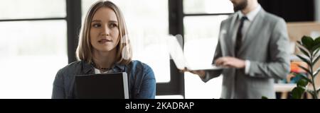 Tensed woman holding resume during job interview in office, banner,stock image Stock Photo
