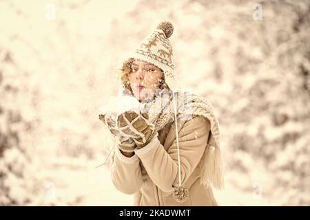 happy woman blow snow from hands. girl in trendy winter coat. girl wear warm mittens and hat. good mood any weather. winter and people concept. having Stock Photo