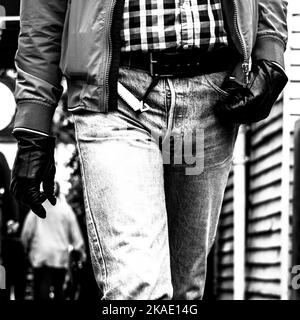 Epsom Surrey, UK, May 28 2022, Close Up Of A Man Walking Towards Camera Wearing Denim Jeans And Black Leather Gloves In Black And White Stock Photo