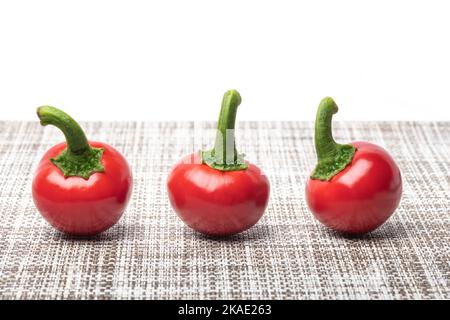 Bright ripe round red chili peppers cuts and seeds on cloth isolated white Stock Photo