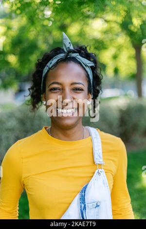 Smiling young african american woman looking at camera outdoors Stock Photo