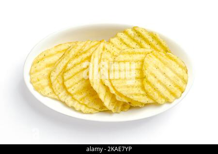 Wasabi and nori flavored salted ruffles, ruffled potato chips, in a white bowl. Crinkle-cut potatoes, deep fried in oil until crunchy. Stock Photo