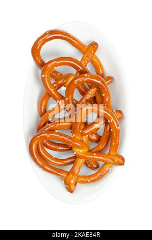 Salted hard pretzels, also known as Brezel, in a white bowl. Popular, traditional and crunchy snack. A type of baked bread, made from dough. Stock Photo