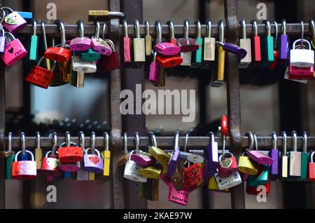 A closeup shot of the padlocks hanging on wall as symbols of love. Italy Stock Photo