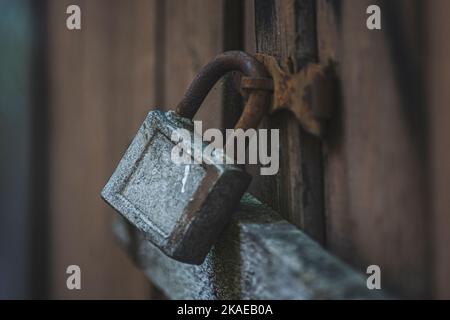 Old rusted padlock and metal fragments on old colorful wooden doors Stock Photo