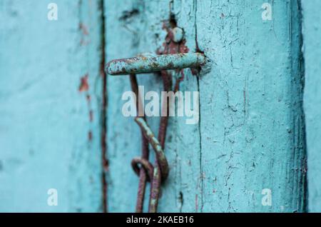 Old rusted padlock and metal fragments on old colorful wooden doors Stock Photo