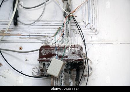 An old dirty telephone or electrical junction box on the wall. Selective focus Stock Photo