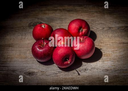 Red apples on a rustic wooden work surface Stock Photo