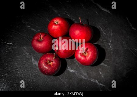 Red apples on a black marble work surface. Stock Photo