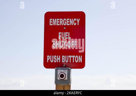 A red emergency sign "fuel shut-off, push button" placed at the gas station Stock Photo