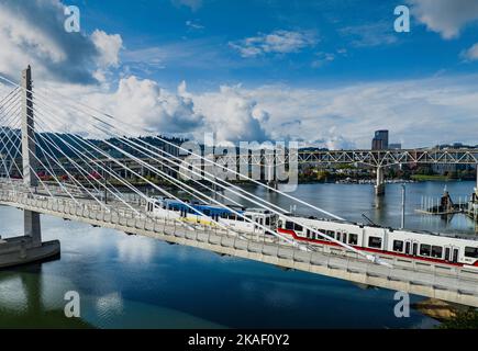 Tilikum Crossing, Bridge of the People is a cable-stayed bridge across the Willamette River in Portland, Oregon, United States. It was designed by TriMet, the Portland metropolitan area's regional transit authority, for its MAX Orange Line light rail passenger trains. The bridge also serves city buses and the Portland Streetcar, as well as bicycles, pedestrians, and emergency vehicles. Private cars and trucks are not permitted on the bridge. It is the first major bridge in the U.S. that was designed to allow access to transit vehicles, cyclists and pedestrians but not cars. Stock Photo