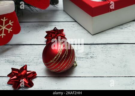 Christmas red and silver background with balls, bows, Christmas sock and gifts on a wooden table with copy space Stock Photo