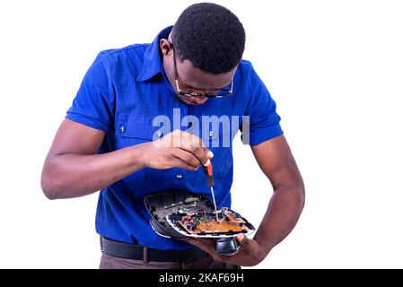 young man technician repairing mobile phone with screwdriver. Stock Photo