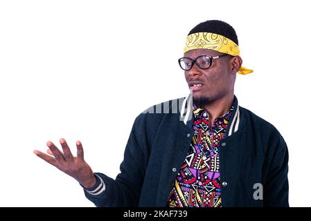 handsome surprised young man wearing yellow bandana and optical glasses while holding an empty palm. Stock Photo