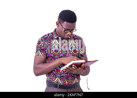 portrait of the handsome young serious businessman wearing glasses, while reading the notebook. Stock Photo