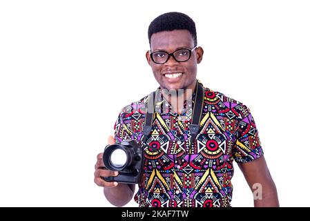 portrait of handsome young man photographer holding camera while smiling at camera. Stock Photo