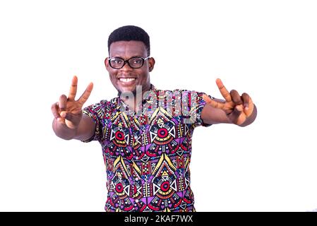 young happy man in optical glasses, showing victory or peace sign with fingers while smiling at camera. Stock Photo