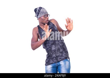 a young casual man standing on white background wearing bandanna making refusal gesture Stock Photo