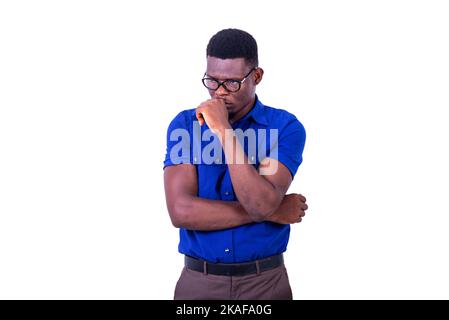 pensive young man wearing optical glasses, looking sideways with folded arm and raised hand on chin. Stock Photo