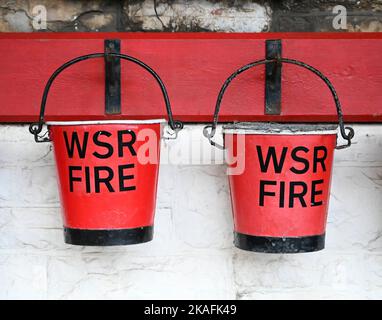 Red fire buckets hanging on a wall Stock Photo