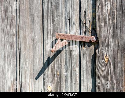 Old rusty forged metal door lock on a a wooden door close up Stock Photo