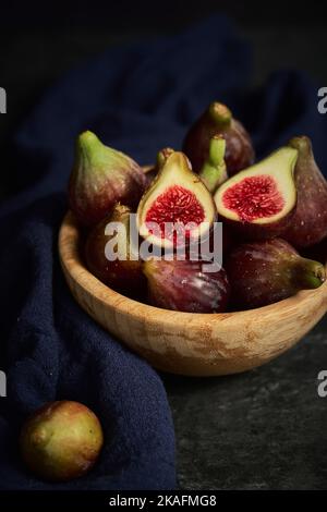 juicy fig berries in a wooden bowl Stock Photo