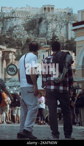 A vertical shot of two men looking at the Acropolis in the center of Athens, Greece. Stock Photo