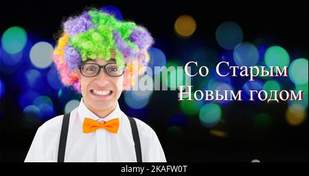 Portrait of cheerful young caucasian man wearing colorful wig by russian orthodox new year text Stock Photo