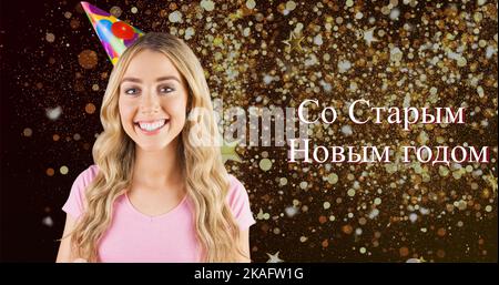 Portrait of smiling young caucasian woman by russian orthodox new year text over confetti Stock Photo