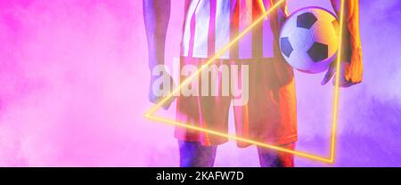 Midsection of african american male player holding ball with illuminated triangle shape over smoke Stock Photo