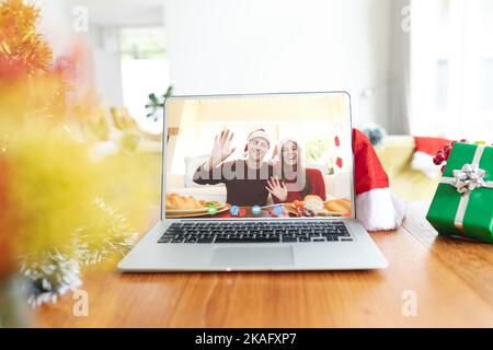Caucasian couple having christmas video call on laptop screen Stock Photo