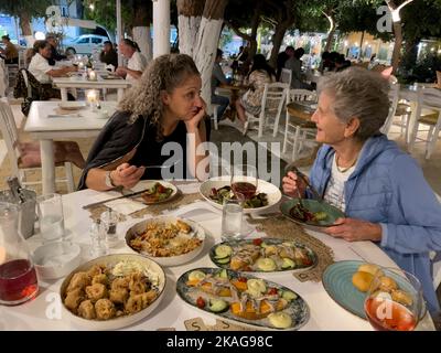 Malia, Crete, Greece. 2022. Two women in a Greek restaurant enjoying a selection of Cretan dushes. Stock Photo