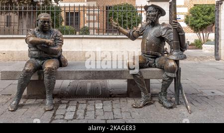 Statues of Don Quixote and Sancho Panza sit on a bench outside the birthplace of Miguel de Cervantes Savedra, Alcala de Henares near Madrid, Spain Stock Photo