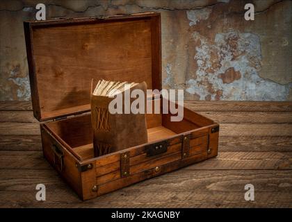 retro decorative case or storage box on wooden rustic table with an old journal or book inside Stock Photo