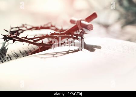 The crown of thorns symbolizing the sacrifice, suffering and resurrection of Jesus Christ on the cross and the background of the Bible Stock Photo