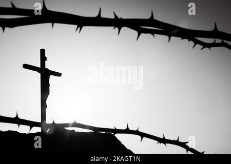 Crown of thorns symbolizing the sacrifice, suffering and resurrection of Jesus Christ on the cross and Easter light background Stock Photo