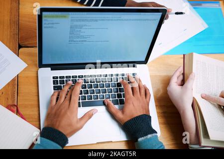 Its time to type out that assignment. a university student doing some research on a laptop. Stock Photo