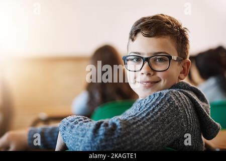 Happy to be in class. Rearview portrait of an elementary school boy sitting in the classroom. Stock Photo
