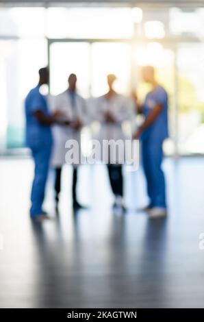 In it together for the sake of your health. Blurred shot of a team of doctors standing together in a hospital. Stock Photo
