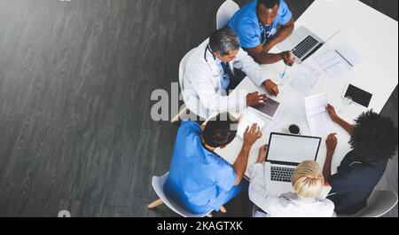 Discussing treatment options as a team. High angle shot of a team of doctors having a meeting in a hospital. Stock Photo