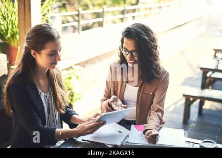 They work best when they collaborate. two designers having a meeting at a coffee shop. Stock Photo