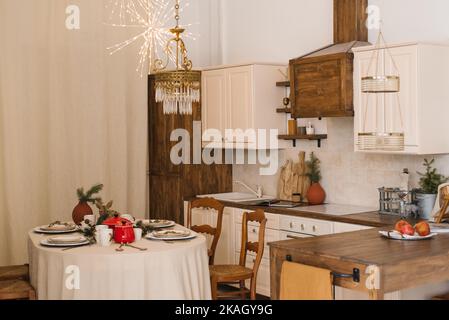 Christmas living room with a festive dining table with wooden chairs in Scandinavian style Stock Photo