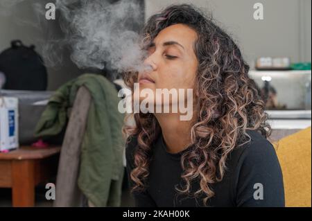 Close up shot of woman blowing out smoke Stock Photo